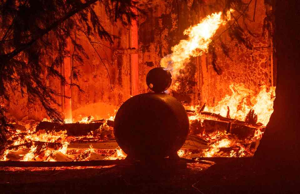  A propane tank burns along with a home as wind and embers rip through the area