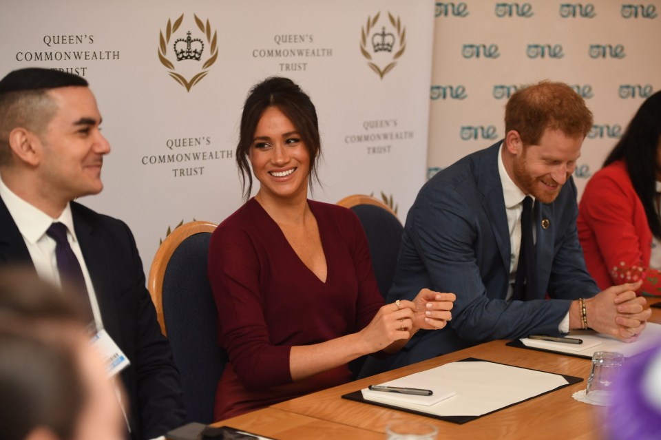 Prince Harry and Meghan Markle laugh as they speak with young leaders at Windsor Castle