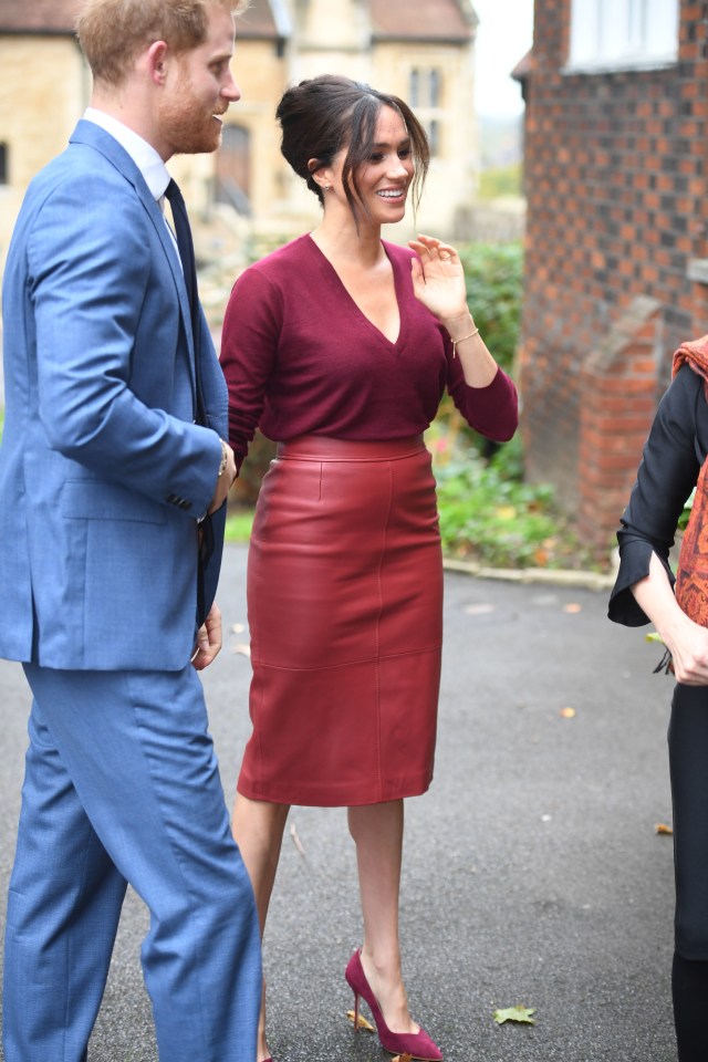 Meghan wore a Hugo Boss pencil skirt and matching red pumps