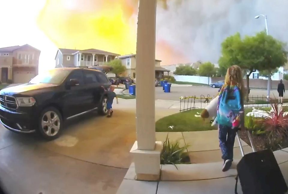  A child runs out with suitcases as thousands of families were displaced by the blaze