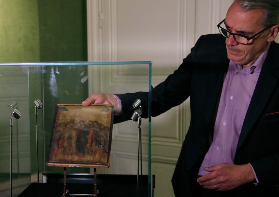  Art expert Stephane Pinta takes the painting out of a glass case in Paris