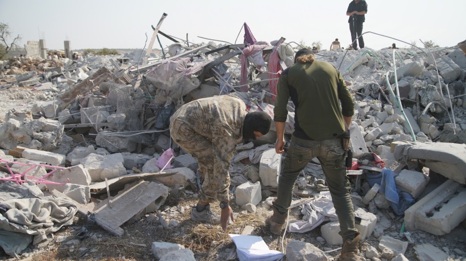 Fighters pick through the rubble of the compound, which was destroyed after the raid