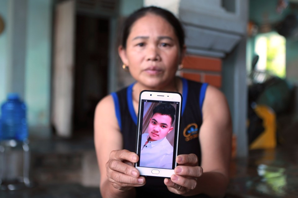  Hoang Thi Ai holds up her phone showing a photo of her missing son, Hoang Van Tiep