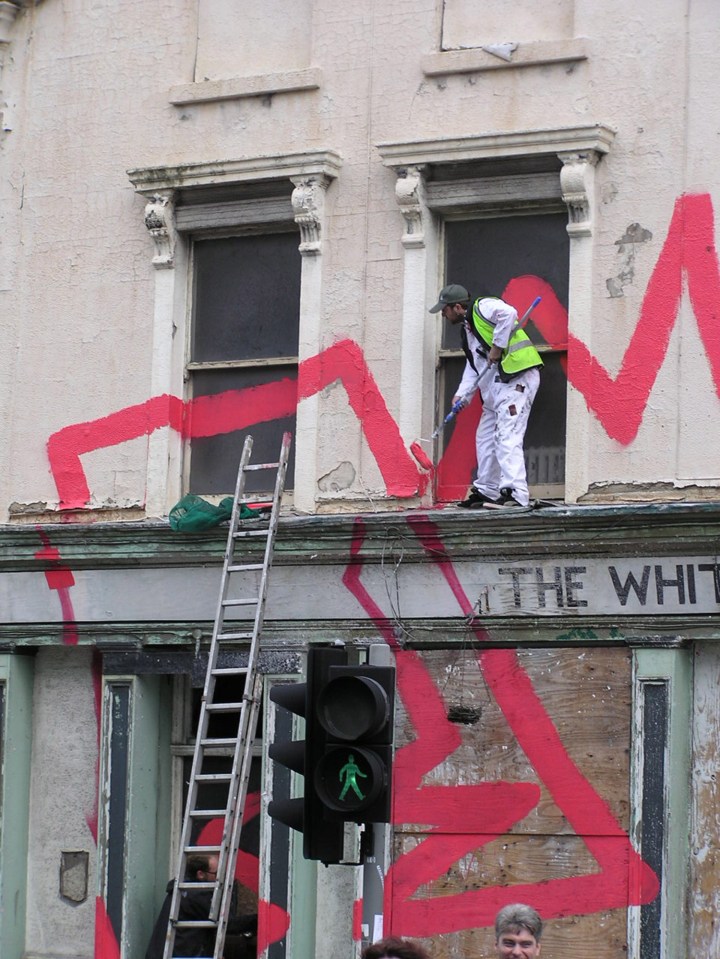  This snap of a workman in a hi-viz jacket painting one of Banksy's works was taken in Liverpool in 2004