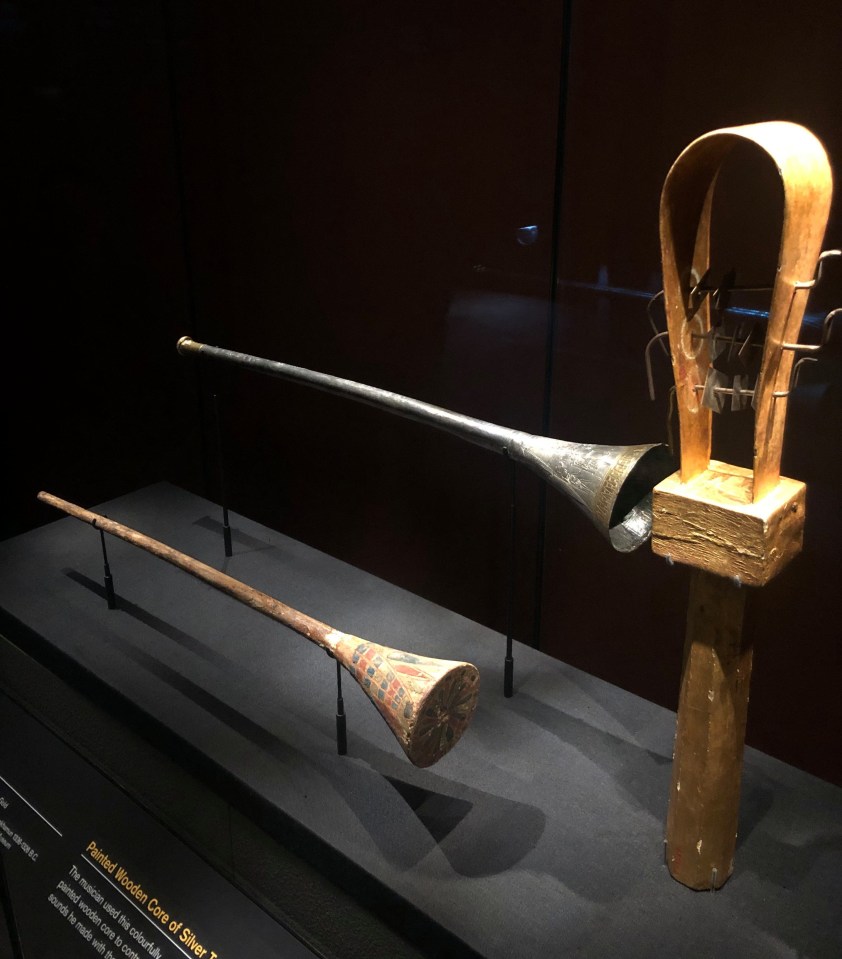 The cursed trumpet is displayed next to its painted wooden core