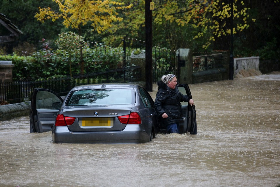  A BMW driver gets stuck trying to drive through deep flood water as it rises in the village of Whiston near Sheffield