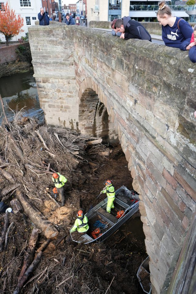  Environment Agency staff work to clear the debris blocking the central arches on the Wye Bridge in Hereford