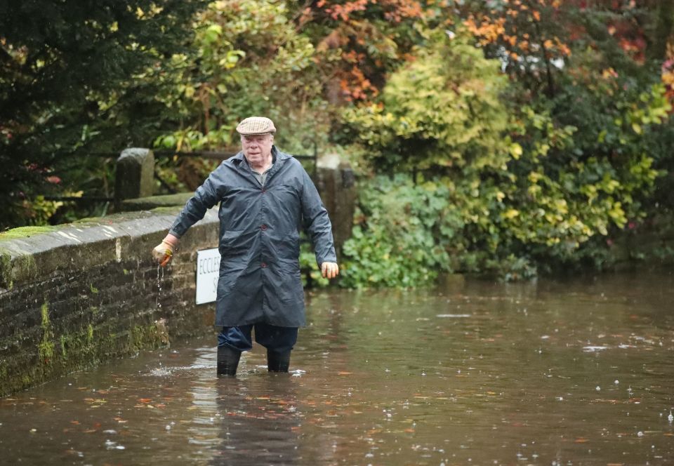  A man wades through the floods in the village of Whirlow near Sheffield