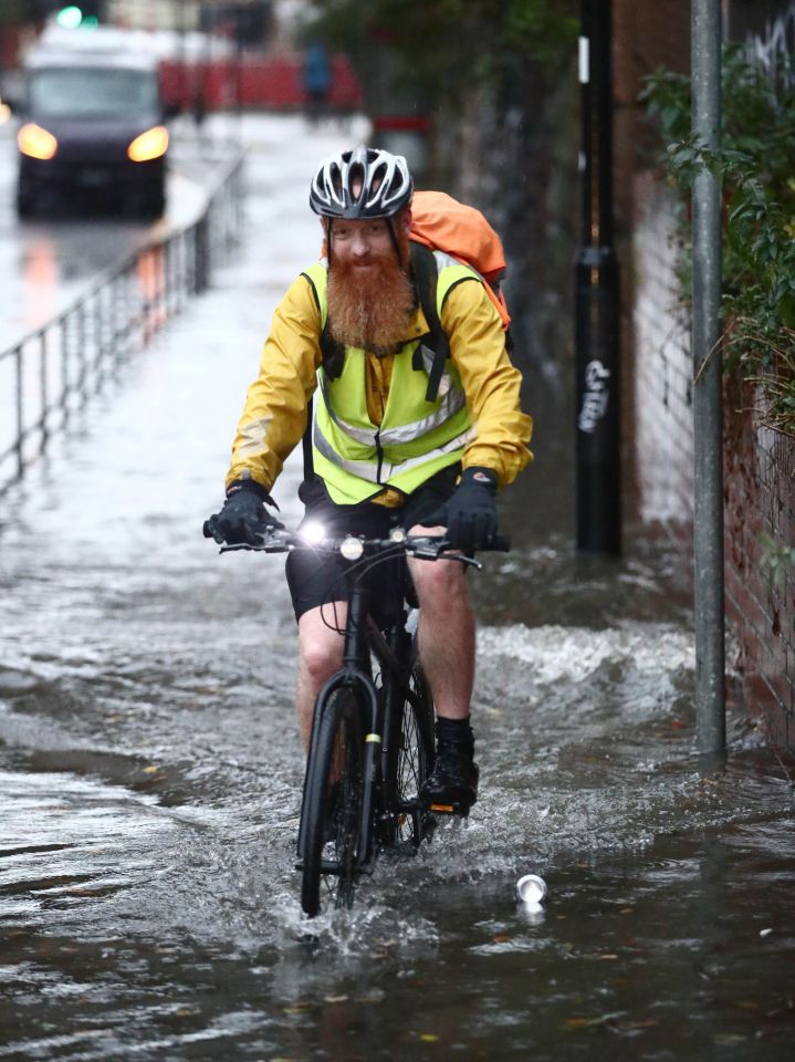  A hardy cyclist in Sheffield takes on the flood water