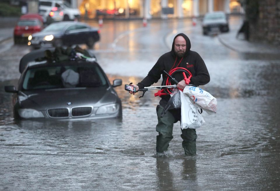  UK flooding: A man wades through a flooded street in Sheffield this afternoon