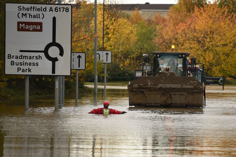  A rescuer wades through chest-deep water in Rotherham