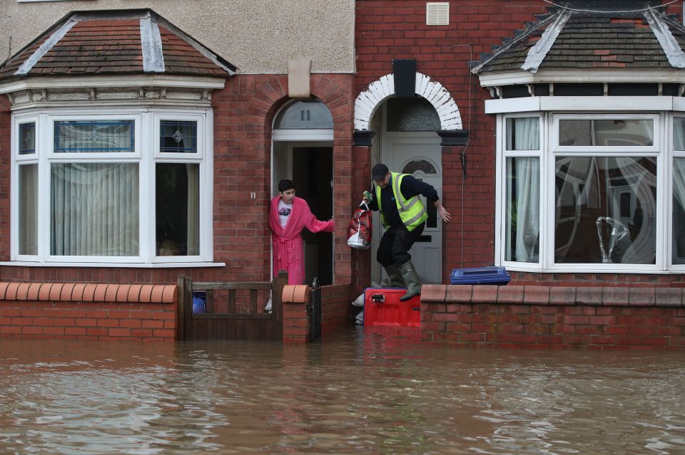  People attempt to walk through flood water on Yarborough Terrace in Doncaster, Yorks.