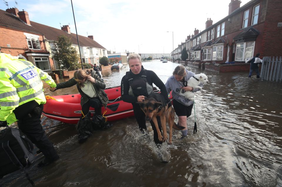  A dog is carried to safety on Yarborough Terrace in Doncaster, Yorks.