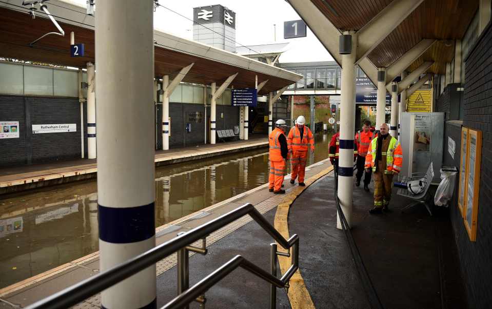  Workers inspect flooded rail tracks at Rotherham Central train station