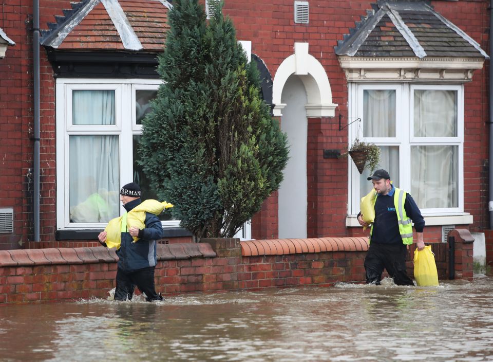  People carry sandbags on Yarborough Terrace in Doncaster, Yorks.