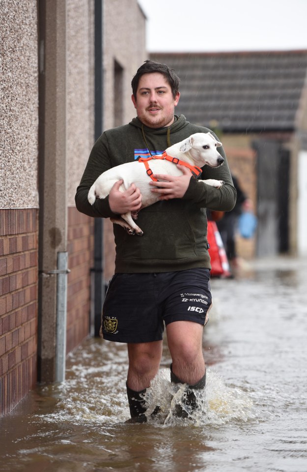  Resident Jamie Needham rescues his dog Mason from his flooded home near Doncaster town centre