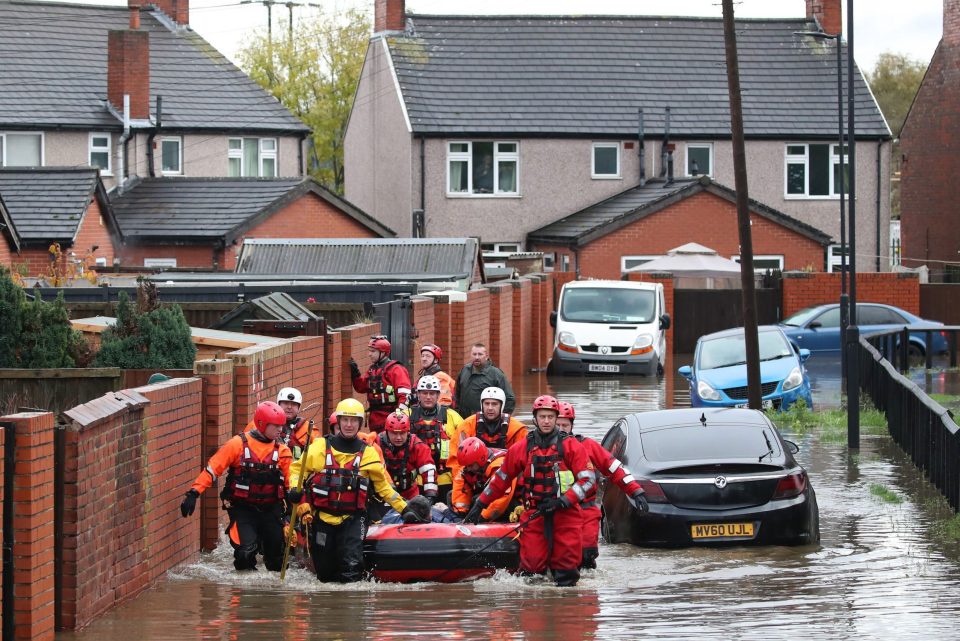  Fire and Rescue service workers pull an inflatable boat used to rescue residents trapped by floodwater in Doncaster