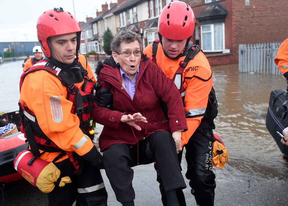  Firefighters evacuate an elderly lady from her flooded home in the Bentley suburb of Doncaster