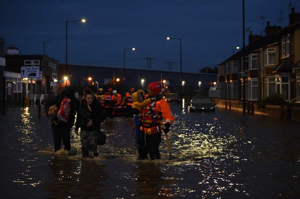  Firefighters wade through flooded streets in Doncaster tonight amid the major rescue operation