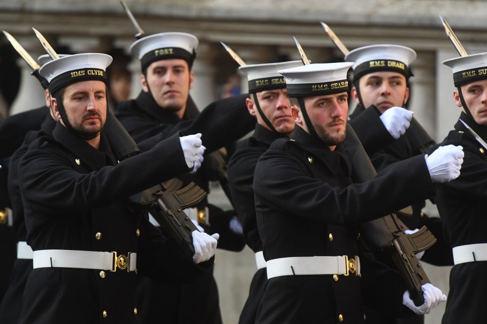  Members of the armed forces march during the service