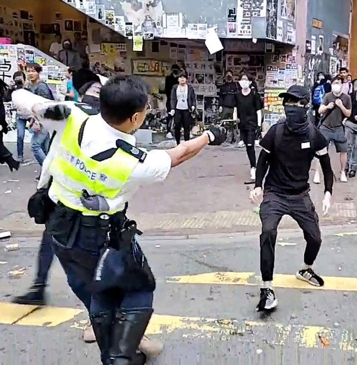  In another shocking video, a masked protester was shot at close range in a busy street