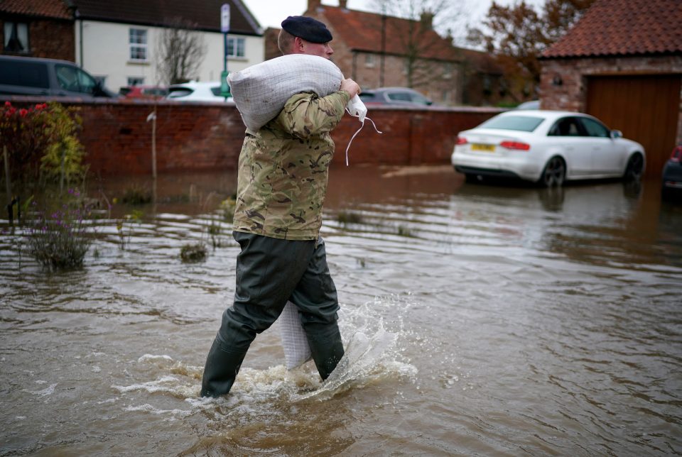  A soldier trudges through water with a sandbag as the army help homeowners in Fishlake