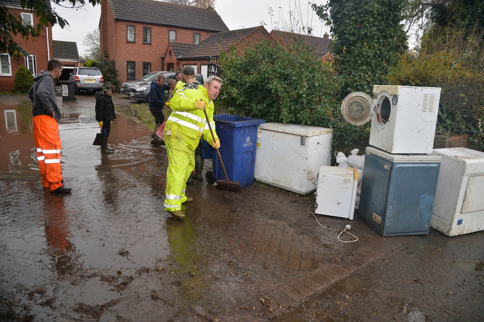  Workers help to clean up a heavily-flooded house in Doncaster