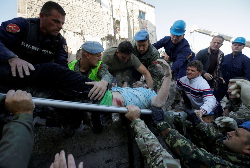  A wounded man is stretchered away from a collapsed building in Albania