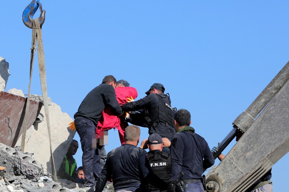  The body of a girl, 5, is removed from the rubble