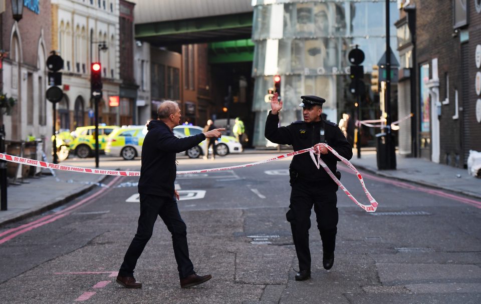  Police have cordoned off the area, with an officer seen here directing a member of the public away from the horror