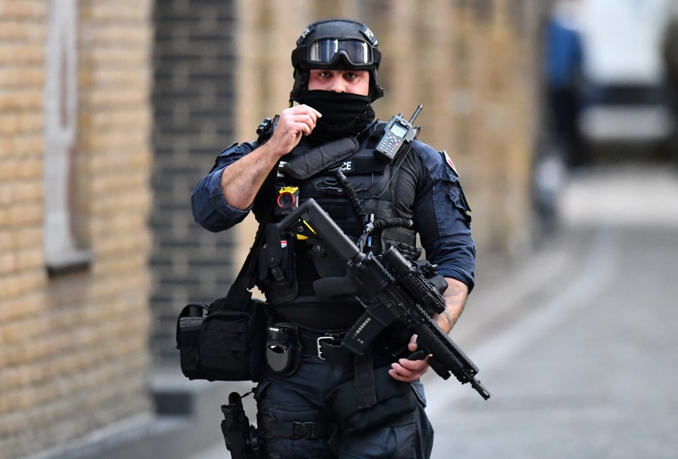 A police officer can be seen in the aftermath