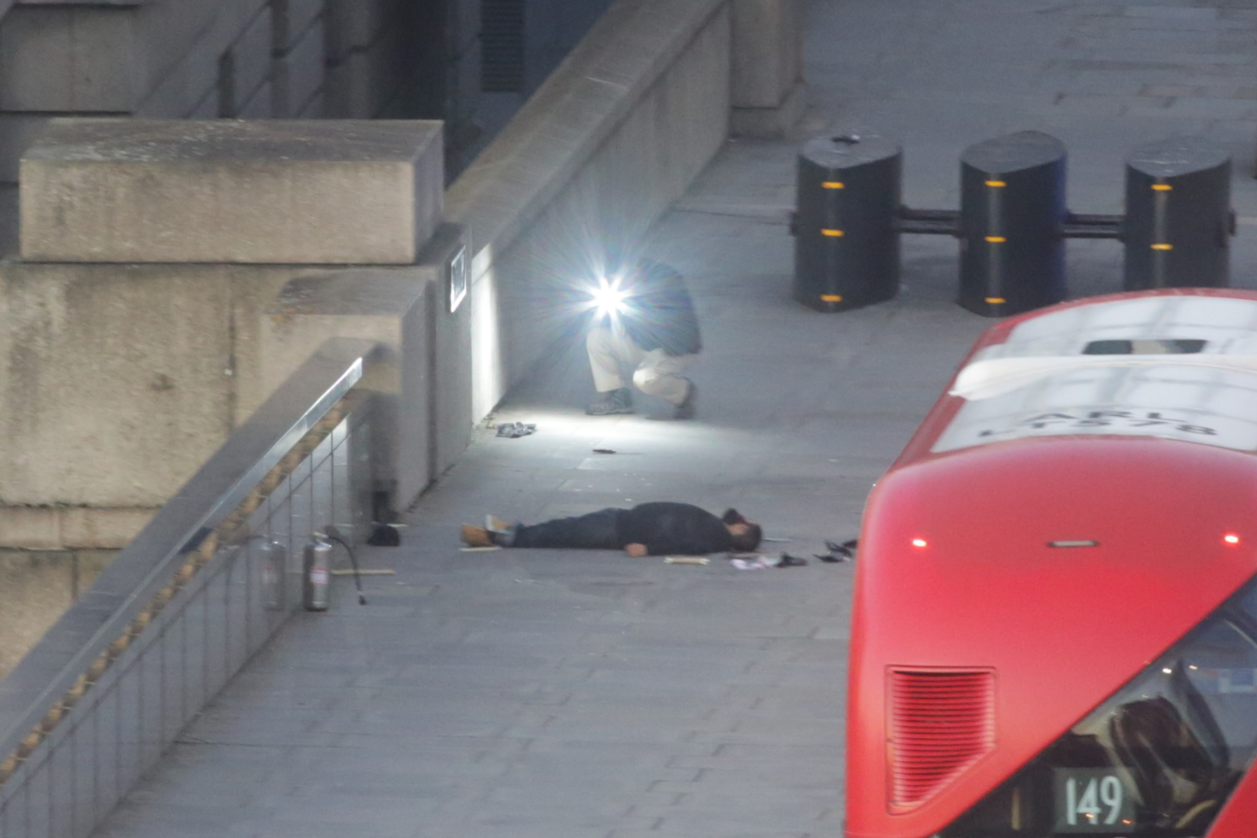  Usman Khan can be seen lying on London Bridge after being shot by police and chased by witnesses armed with sticks and a fire extinguisher