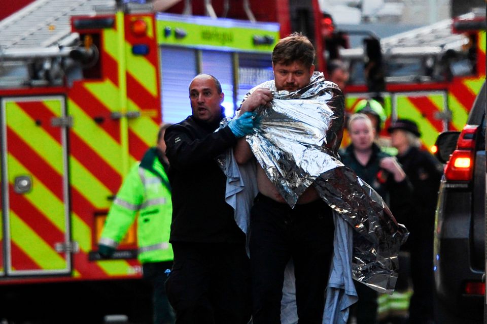  An injured man is helped away from the scene of the bloody London Bridge attack, in which two people died