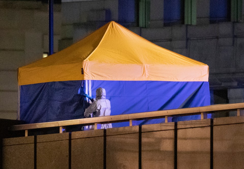 A blue forensic tent is set up on the bridge in the aftermath