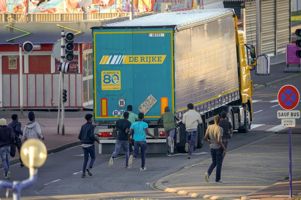  Migrants try to board a lorry at Ouistreham, France, ferry port in the hope of reaching the UK