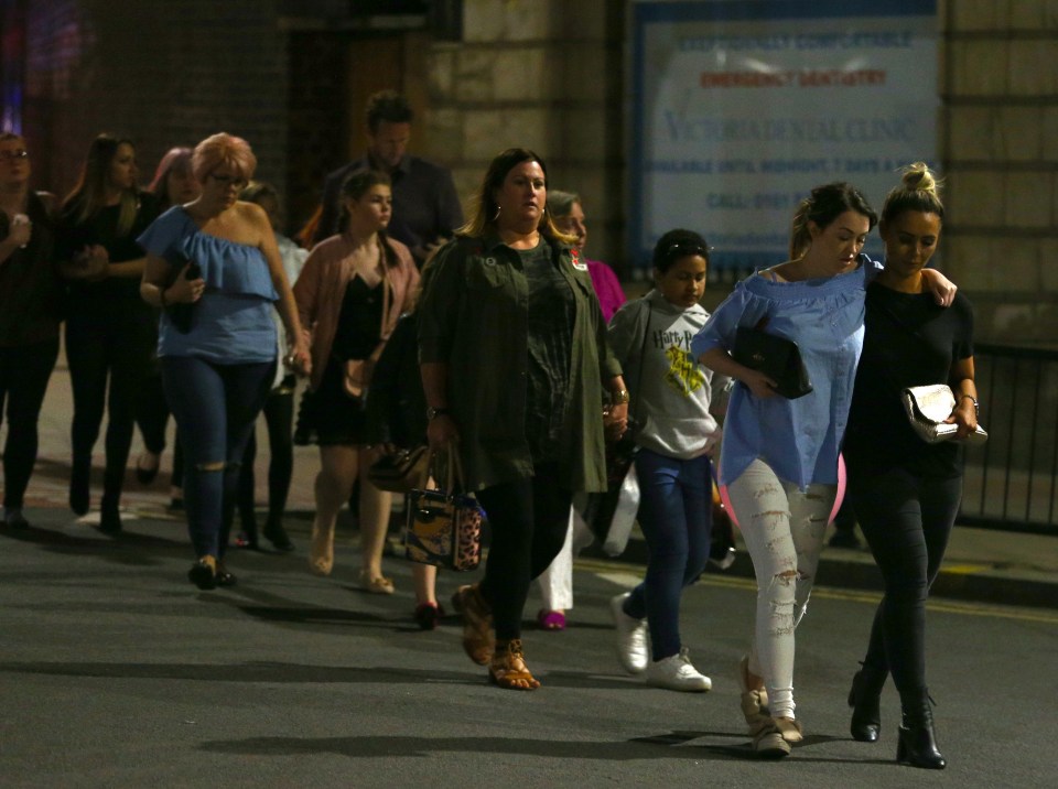  Members of the public are escorted from the Manchester Arena on May 23, 2017