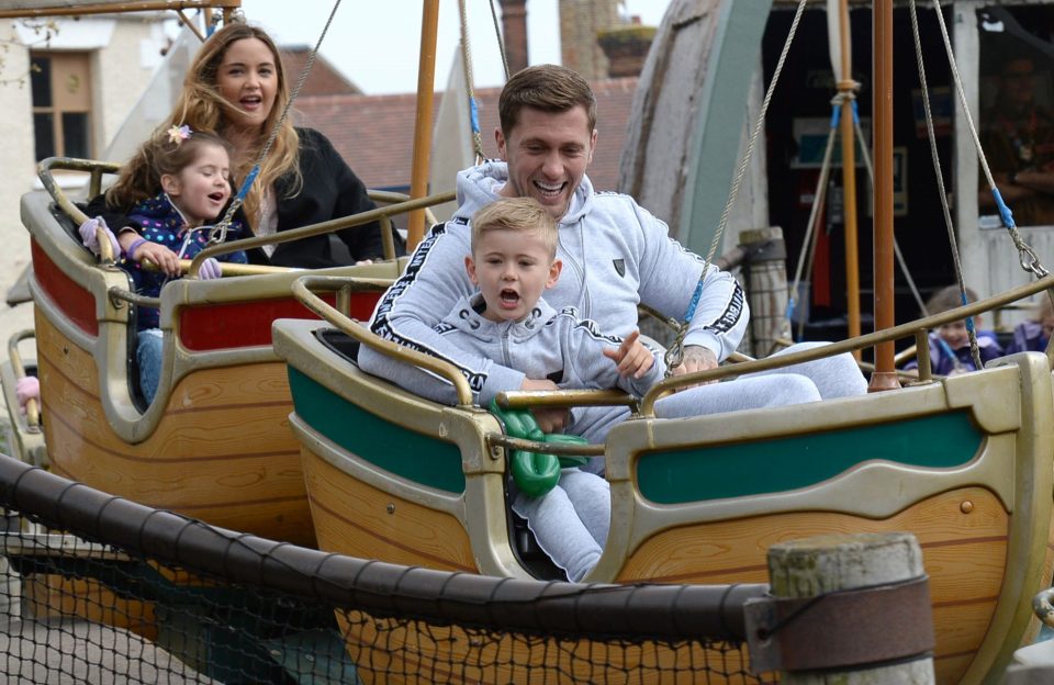  The couple beam as they enjoy a theme park ride with Ella and Teddy