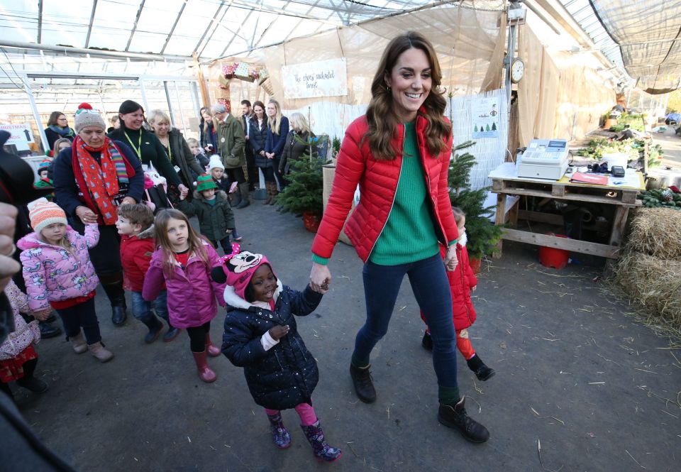 Kate holds a little girl's hand as she leads her outside to pick a tree