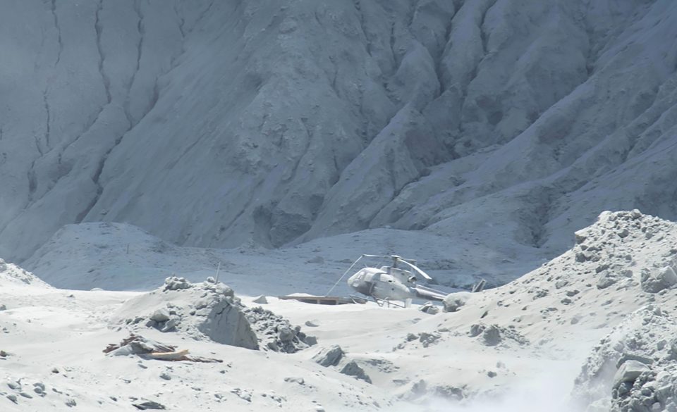  A helicopter is seen on the island covered in ash after the eruption