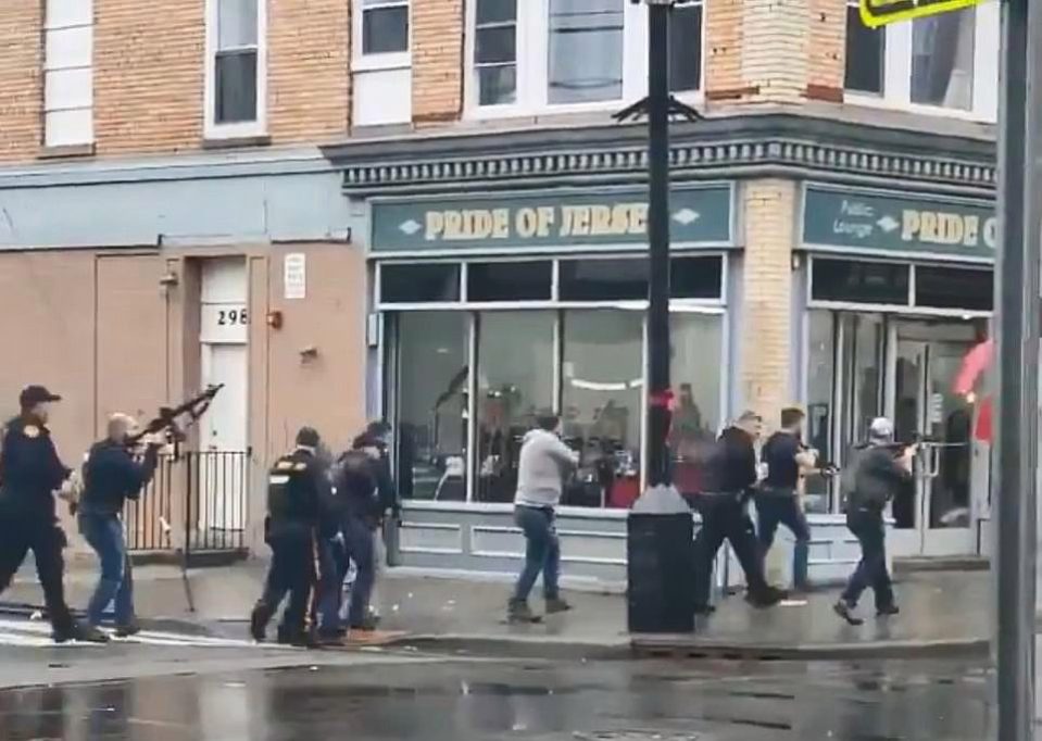  Police officers descend on a kosher grocery store where two murder suspects holed up amid a lengthy firefight Tuesday.