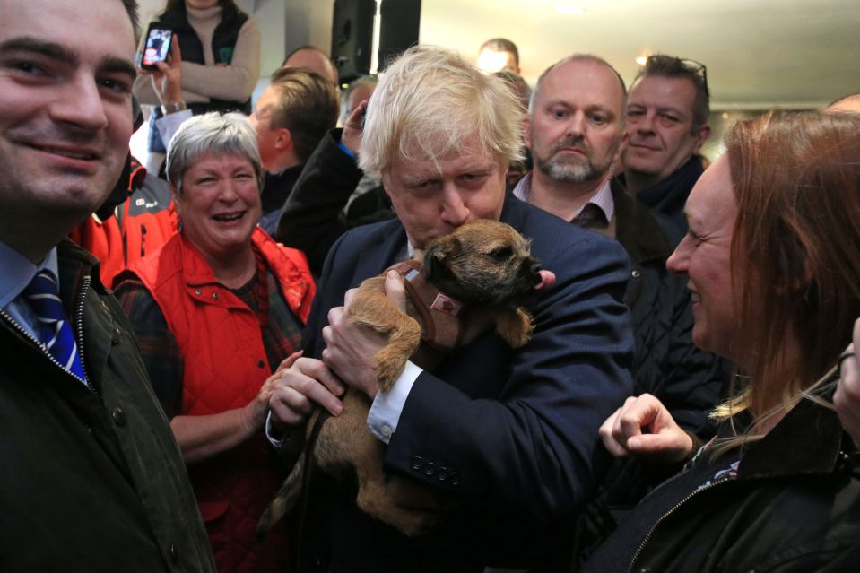  Boris poses with a supporter's dog in Sedgefield yesterday after his huge election victory