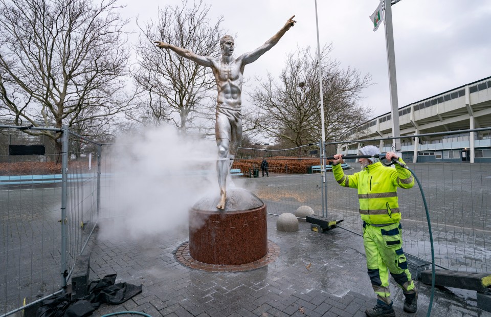  Worker tries to clean silver spray paint off the Zlatan statue