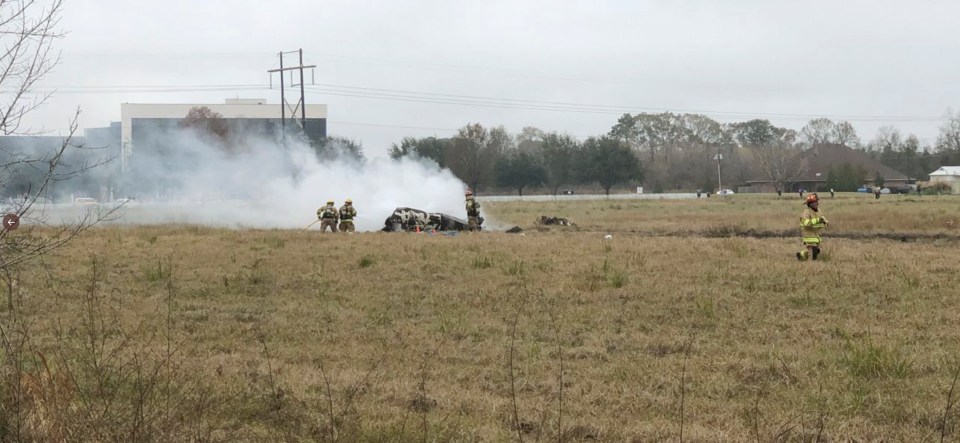  First responders examine the wreckage near Feu Follet Road and Verot School Road in Lafayette