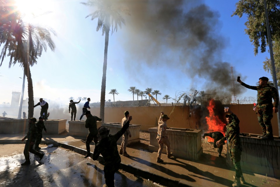  Hashd al-Shaabi fighters set fire to a US Embassy wall in Baghdad after air strikes targeted Iran-backed militia