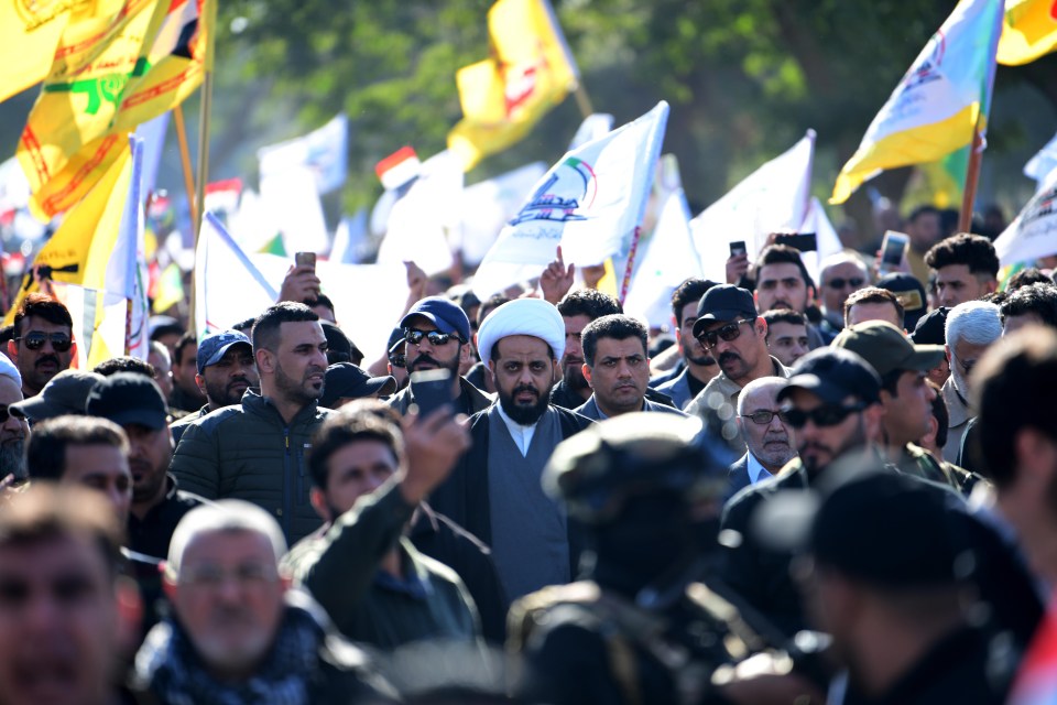  Shiite warlord Qais al-Khazali (centre) marches on the embassy in protest at US air strikes