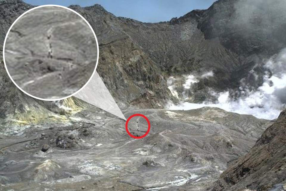  A group are photographed trekking across the crater in the moments before it erupted