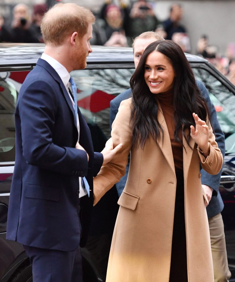  Prince Harry touches his wife's arm as they arrive to visit the Canadian High Commissioner