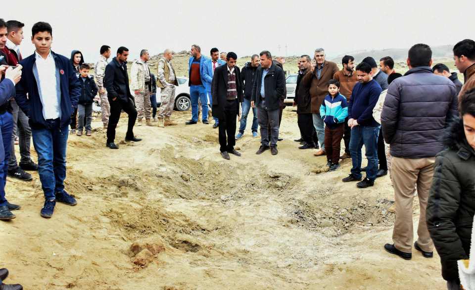  Iraqi Kurds inspect a crater caused by one of the Iranian missiles