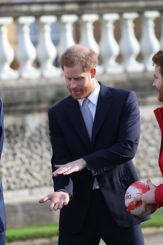  Prince Harry mimes his rugby skills in the palace gardens