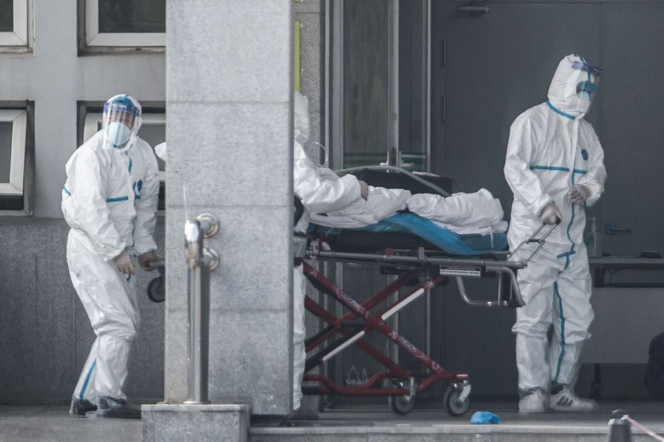  Medics in protective suits carry a patient into Jinyintan hospital in Wuhan